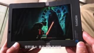 Un prototip de ecran pliabil AMOLED este prezentat în acţiune în mâna unui tester
