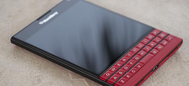 Varianta de culoare roșie a lui BlackBerry Passport scoasă din cutie În fața camerei