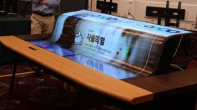 <b>LG Display prezintă un panou OLED flexibil de 77 inch; pe deasupra este și transparent</b>Filiala LG Display a prezentat astăzi un produs inedit, un panou OLED flexibil cu diagonala de 77 inch și rezoluție 4K Ultra HD care pe deasupra este și transparent. Creația sud-coreenilor a fost expusă de curând în cadrul unui târg de tehnologie și